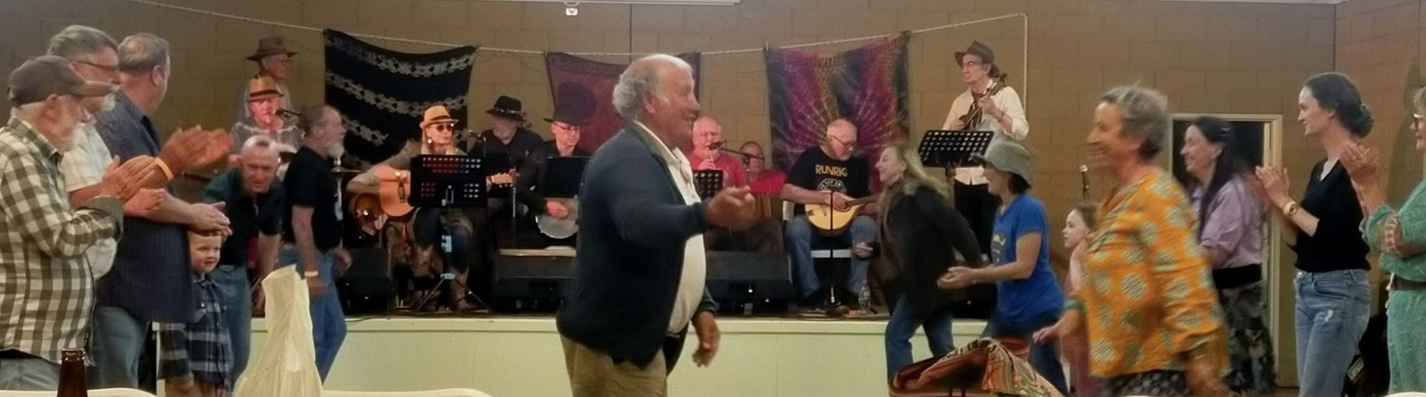 people dancing and clapping with band in background